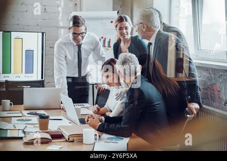 Team aziendale di successo che analizza le vendite mentre si tiene una riunione del personale nella sala del Consiglio Foto Stock