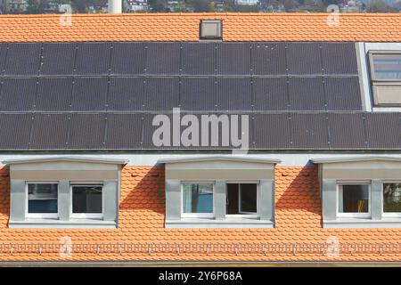 Pannelli solari sul tetto di una casa cittadina con finestre a goccia, Germania Foto Stock