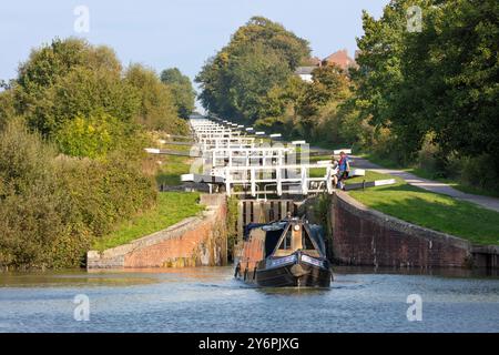 Imbarcazioni a remi che attraversano le chiuse di Caen Hill sul canale Kennet e Avon, Devizes, Wiltshire, Inghilterra, Regno Unito, Europa Foto Stock