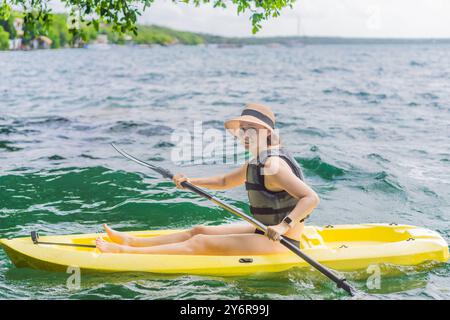 Donna in kayak sul lago Bacalar in Messico. Turismo d'avventura a Quintana Roo, esplorazione all'aperto e attività acquatiche Foto Stock