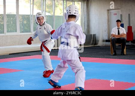 ODESSA,UCRAINA- Settember21, 2024: Bambini e sport giovanili. Bambini-ragazzi e ragazze conducono combattimenti di karate su sport per bambini tatami. Vita sana Foto Stock