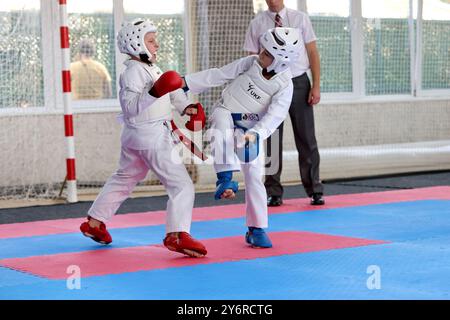 ODESSA,UCRAINA- Settember21, 2024: Bambini e sport giovanili. Bambini-ragazzi e ragazze conducono combattimenti di karate su sport per bambini tatami. Vita sana Foto Stock