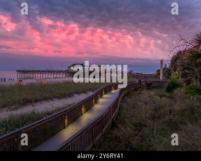 Passeggiata sul lungomare di Myrtle Beach con ristorante Pier 41, dune di sabbia da sogno e colorato cielo al tramonto nel South Carolina USA Foto Stock