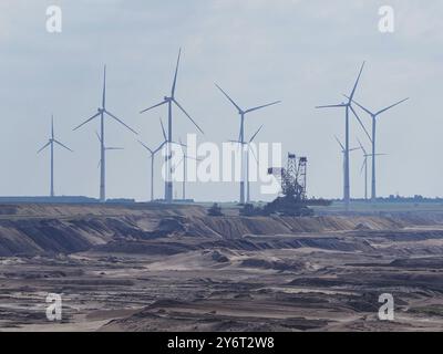 Turbina eolica per la produzione di energia elettrica ai margini della miniera di lignite a cielo aperto di Garzweiler, di fronte a un grande escavatore, l'area mineraria della lignite renana, GE Foto Stock