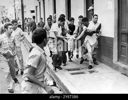 21 GENNAIO 1962 UN GIOVANE FERITO VIENE PORTATO IN OSPEDALE DOPO UNO SCONTRO CON LE TRUPPE DURANTE LE RIVOLTE SCOPPIATE DOPO CHE UNA GIUNTA MILITARE PRESE IL CONTROLLO A SANTO DOMINGO, REPUBBLICA DOMINICANA. Foto Stock