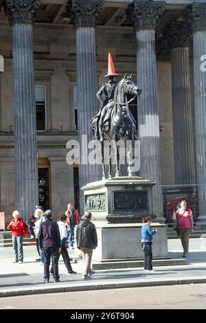 Glasgow, Scozia, settembre 2024, una statua equestre raffigurante il Duca di Wellington a cavallo del suo cavallo, è stata sormontata da un cono stradale. Foto Stock