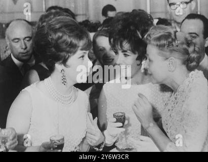 Due famose bellezze, entrambe con lo stesso abito Dior, ritratte a un ricevimento per le stelle che partecipano al Festival del Cinema di Mosca, sono l'italiana Gina Lollobrigida (a sinistra) e Elizabeth Taylor (al centro). Si vedono parlare con il ministro sovietico della cultura Ekaterina Furtseva. Il ricevimento si è tenuto la sera del 15 luglio 1961 al Cremlino di Mosca, URSS. 17 LUGLIO 1961 Foto Stock