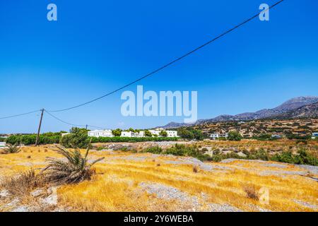 Paesaggio asciutto con montagne ed edifici bianchi sull'isola di Creta sotto il cielo azzurro e limpido il giorno d'estate. Grecia. Foto Stock