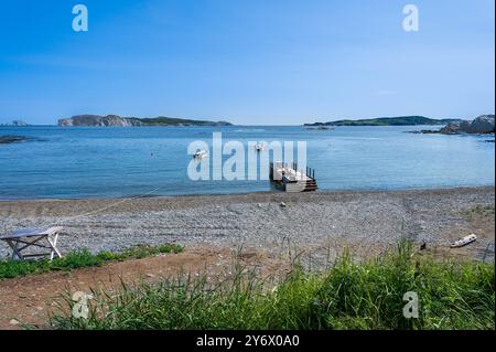 acque calme in una baia riparata con barche ormeggiate fuori dal molo. Foto Stock