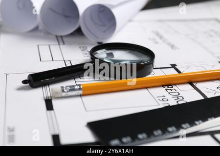 Diversi disegni architettonici, matita, righello e lente d'ingrandimento sul tavolo, primo piano Foto Stock