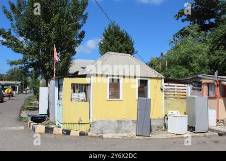 Casa gialla abbandonata con elettrodomestici davanti a St. Johns, Antigua Foto Stock