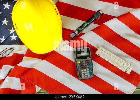 La bandiera degli Stati Uniti con l'equipaggiamento di sicurezza è esposta su uno sfondo rustico in legno per celebrare il Labor Day Foto Stock