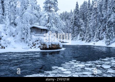 Fiume con blocchi di ghiaccio che si snodano nelle rapide di Myllykoski, sul fiume Kitkajoki, tutto coperto di neve in inverno nel Parco Nazionale di Oulanka. Juuma Kuusamo Finlandia Foto Stock