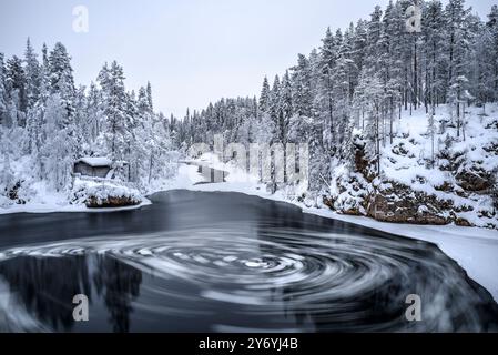 Fiume con blocchi di ghiaccio che si snodano nelle rapide di Myllykoski, sul fiume Kitkajoki, tutto coperto di neve in inverno nel Parco Nazionale di Oulanka. Juuma Kuusamo Finlandia Foto Stock