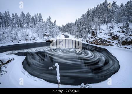 Fiume con blocchi di ghiaccio che si snodano nelle rapide di Myllykoski, sul fiume Kitkajoki, tutto coperto di neve in inverno nel Parco Nazionale di Oulanka. Juuma Kuusamo Finlandia Foto Stock