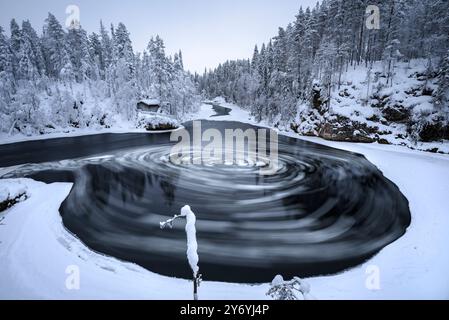 Fiume con blocchi di ghiaccio che si snodano nelle rapide di Myllykoski, sul fiume Kitkajoki, tutto coperto di neve in inverno nel Parco Nazionale di Oulanka. Juuma Kuusamo Finlandia Foto Stock