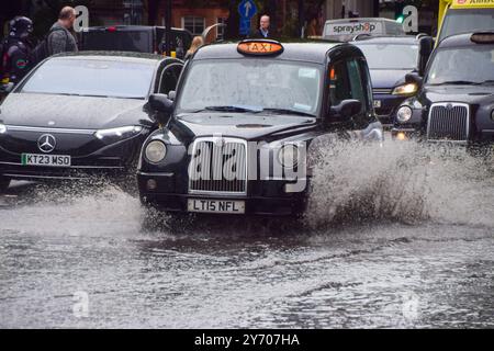 Londra, Inghilterra, Regno Unito. 27 settembre 2024. Un taxi si tuffa attraverso una Euston Road che si è depositata in acqua, mentre in Inghilterra vengono emessi altri avvisi di inondazione in mezzo a forti piogge. (Credit Image: © Vuk Valcic/ZUMA Press Wire) SOLO PER USO EDITORIALE! Non per USO commerciale! Foto Stock