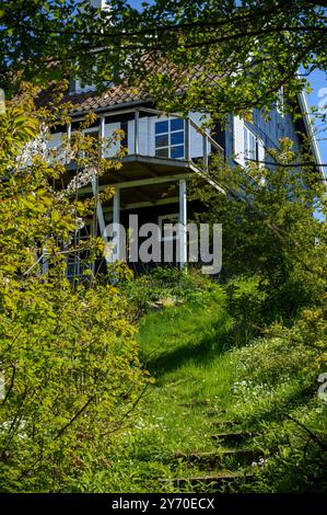 Una vecchia casa residenziale in legno circondata da un giardino. Primavera, maggio, giorno di sole Foto Stock