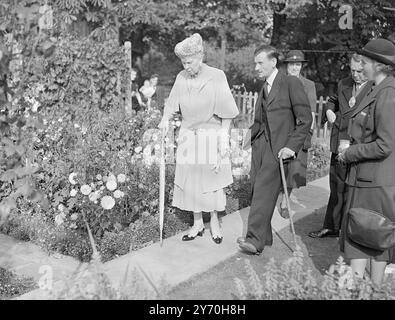 LA REGINA MARIA, ILLESA, COMPIE UN INGAGGIO DOPO IL CROLLO DEL VAR. LA FOTO MOSTRA: La Regina Maria presenta la Coppa per il miglior giardino ' Pre-Fab' di Londra al signor . William Mucklow nel suo pre-fab a Rosendale Close , West Dulwich , Londra . 20 settembre 1949 Foto Stock