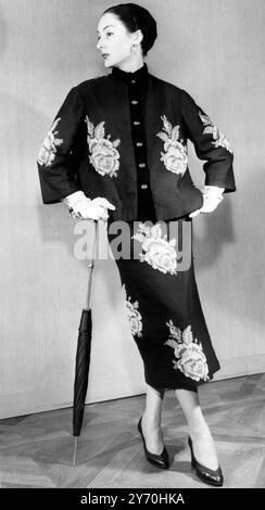 Prendendo spunto dal libro della nonna , la designer de Givenchy di Parigi produce questo elegante abito pomeridiano "arazzo" . E' in punta ad ago nera, decorata con rose completamente soffiate e foglie di verde brillante. La giacca in stile cardigan, lunga all'anca, è rifinita con velluto nero per abbinarsi al cappello toque. Agosto 1952 Foto Stock