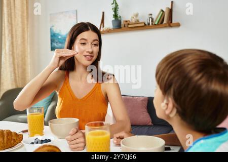 Una madre amorevole si impegna con il figlio con problemi di udito durante una colazione gioiosa. Foto Stock