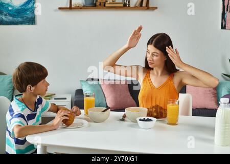 Una madre si impegna con il figlio con problemi di udito durante una colazione calda a casa loro. Foto Stock