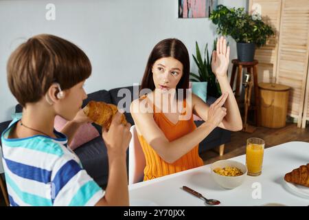 La madre coinvolge suo figlio nell'apprendimento del linguaggio dei segni mentre si godono la colazione insieme. Foto Stock