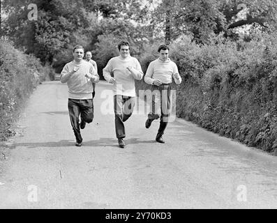 MILLS INIZIA L' ALLENAMENTO FINALE Freddie Mills , campione mondiale dei pesi mediomassimi , entrò nelle fasi finali di allenamento per il suo combattimento con Bruce Woodcock quando si trasferì dalla sua casa di Brixton ( Londra ) ai quartieri di allenamento Country al Barley Mow di Betchworth ( Surrey ) . Mills tenterà di privare Woodcock dei suoi titoli di pesi massimi britannici , europei e imperiali alla White City , Londra , il 2 giugno . IMMAGINI :- FREDDIE MILLS ( centro) in una corsa di allenamento a Betchworth con i partner di sparring KEN SHAW ( a sinistra ) , campione di Scozia dei pesi massimi e JOHNNY WILLIAMS di Barmou Foto Stock