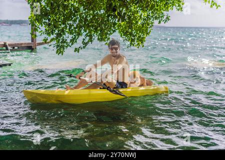 Padre e figlio turisti in kayak sul lago Bacalar in Messico. Turismo d'avventura a Quintana Roo, esplorazione all'aperto e attività acquatiche Foto Stock