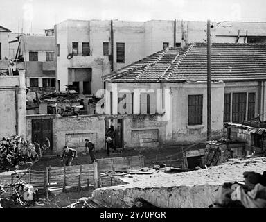 LA FOTO DI JAFFA 'NO MANS LAND', DOPO UNA RICOGNIZIONE ATTRAVERSO TEL AVIV, MOSTRA: Accovacciati per sicurezza questi membri della guardia dell' Haganah , che trasportano armi illegali , si infrangono su una pericolosa strada aperta , sotto fuoco protettivo , dopo aver fatto un raid di ricognizione nel quartiere arabo . Foto scattata mentre attraversavano la "Terra di nessuno" della zona di confine di Tel Aviv Jaffa. 16 dicembre 1947 Foto Stock