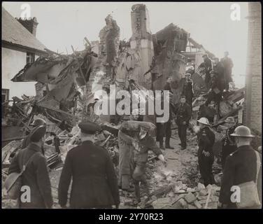 RAIDER NOTTURNO TEDESCO CON 22 BOMBE ABBATTUTE - DISTRUGGE DUE CASE. Un incursore notturno tedesco abbattuto dai cannoni antiaerei di Londra si schiantò a Johnson Road, Bromley, Kent e demolì due case. Alcuni residenti sono sfuggiti alle ferite, altri sono stati ritenuti intrappolati sotto i detriti. Il corpo del pilota nazista, il suo paracadute non aperto, è stato trovato su un tetto vicino. Un altro membro dell'equipaggio che era sceso con paracadute fu catturato. Il bombardiere era un Heinkel. MOSTRA FOTOGRAFICI: Un uomo che porta via dal relitto dell'aereo e dalle case una delle 22 bombe ancora nella bomba quando si schiantò. 10 novembre 1940 C Foto Stock