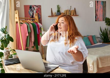 La donna è impegnata in una vivace conversazione telefonica mentre è seduta alla sua scrivania. Foto Stock