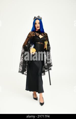 Vestita con uno splendido abito nero, questa donna incarna l'eleganza gotica con i suoi vivaci capelli blu. Foto Stock