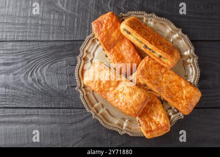 Il Pain Suisse au Chocolat è realizzato con croissant perfetti, ripieno di crema pasticcera fatta in casa vellutata e di gocce di cioccolato da vicino sul piatto Foto Stock