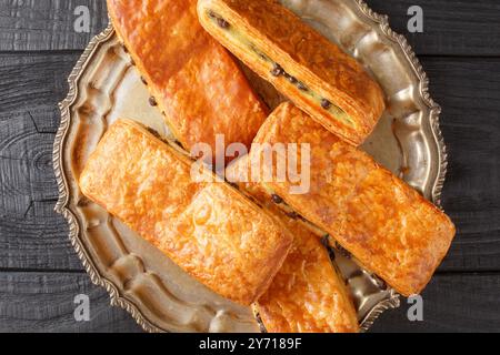 Dolce dolcezza svizzera in stile Suisse preparato con un delizioso impasto di croissant con crema alla vaniglia farcita con gocce di cioccolato primo piano sul piatto Foto Stock