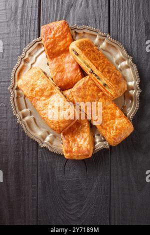 Panini francesi Pain suisse au chocolat con crema pasticcera e gocce di cioccolato da vicino in un piatto su un tavolo. Vista dall'alto verticale Foto Stock