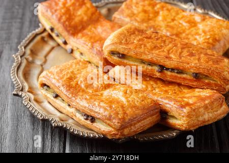 Dolce dolcezza svizzera in stile Suisse preparato con un delizioso impasto di croissant con crema alla vaniglia farcita con gocce di cioccolato primo piano sul piatto Foto Stock