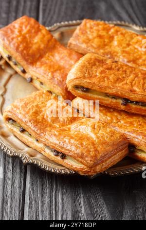 Pain Suisse o Pane Svizzero è una pasticceria tradizionale francese che vanta strati di pasta burrosa e una crema pasticcera avvolgente con un primo piano di cioccolato sul Foto Stock