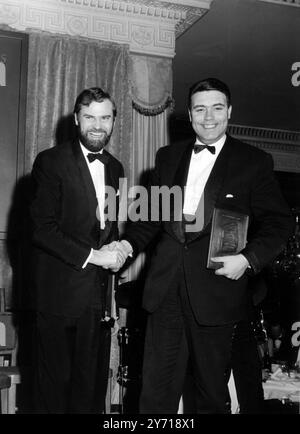 Ray Galton ( a sinistra) e Alan Simpson si congratulano a vicenda alla cena del Screen Writers Guild Award presso l'hotel Dorchester di Londra , dove hanno ricevuto da Lord Willis , il Premio per la serie britannica di intrattenimento leggero o seriale , . in diretta o ripresa. La coppia ha creato e scritto la serie televisiva Steptoe and Son il 12 marzo 1964 Foto Stock