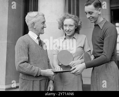 SUGGERIMENTO DI UN VETERANO DI 71 ANNI O .W. TARRANT di Swindon , il più antico concorrente nella sezione veterani dei Campionati di Paddington , Londra , dà qualche Consiglio al campione del mondo JOHNNY LEACH , che è stato battuto ieri nei Campionati inglesi di Paddington , e a Miss PEGGY FRANKS di Londra . Questi due giocano in coppia nella competizione Mixed Doubles . 18 febbraio 1949 . 18 febbraio 1949 Foto Stock