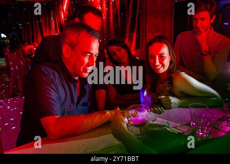 Club a luci rosse in Bulgaria. Competizione in cui l'alcol evaporante di Jägermeister flambé viene inalato con una paglia Foto Stock