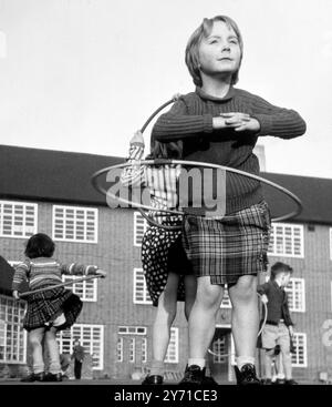 Bambini che giocano con Hula Hoops nel parco giochi della scuola Foto Stock