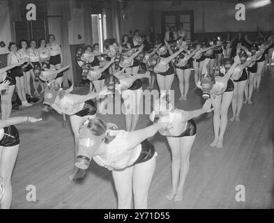 Le donne della Lega della salute e della bellezza dimostrando esercizi mentre indossano maschere antigas 1940 Foto Stock