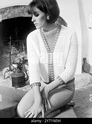 Classico. Firenze, Italia : cardigan lavorato a maglia in lana bianca, con passamaneria in filo d'oro. Questo è di Eva. I pantaloni sono in materiale elastico verde citron di Saba. Giugno 1966 Foto Stock