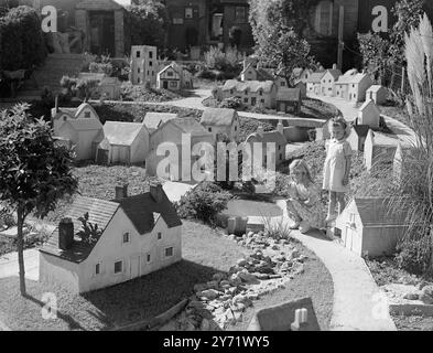 Fairyland in miniatura, Janice Palmer di quattro anni, di Southampton, ha un suo paese fatale in fondo al suo giardino. Suo padre ha costruito per lei un villaggio inglese in miniatura, in un ambiente delizioso a poche centinaia di metri dal trambusto del traffico stradale principale. L'onorevole Palmer, camionista, ha passato più di un anno a contrattare il villaggio, che vanta una chiesa, una fucina, un villaggio verde, e sì - anche il pub è lì. Finora ci sono 85 edifici, ma l'onorevole Palmer è tutt'altro che finito. Saranno aggiunti un cinema, una casa padronale e un castello. Immagini: Villaggio di sua proprietà - Jani Foto Stock