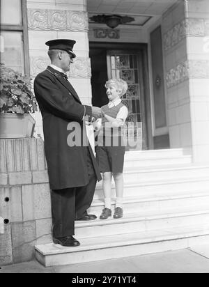 LA STAR DEL CINEMA, FIGLIO DI UNA MADRE FAMOSA. BOBBY HENREY, il ragazzo londinese di 8 anni, che ha riscosso un enorme successo nella produzione di Carol Reed di The Fallen Idol, è il figlio della signora ROBERT HENREY, il celebre scrittore e romanziere Bobby nel film è una delle parti più lunghe e importanti mai date a un giovane da uno studio britannico. La signora Henrey ha appena completato un libro che descrive l'associazione di suo figlio al film intitolato ' Una star del cinema in Belgrave Square'. SPETTACOLI:- Bobby Henrey , star del cinema con il suo amico di lunga data Alfred Crouch , portineria a Carrington House, Foto Stock