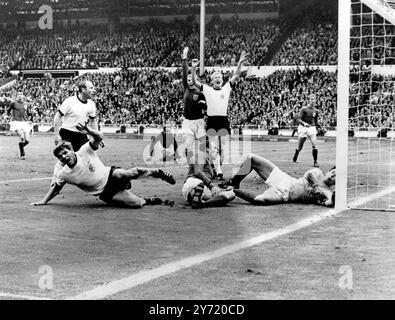 Il gol che ha scosso la finale della Coppa del mondo di calcio Wembley1966 della Germania Ovest Wolfgang Weber urla da terra dopo aver segnato un pareggio negli ultimi secondi dei tempi regolamentari. Anche nelle camicie bianche per la Germania Ovest ci sono Uwe Seeler (a sinistra) e Karl-Heinz Schnellinger (al centro). Per l'Inghilterra Ray Wilson è a terra accanto al portiere Gordon Banks, il capitano Bobby Moore è attraente al centro con Jack Charlton (schiena a destra) e George Cohen (centro) 30 luglio 1966 Foto Stock