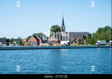 Stokrooie, Hasselt, Belgio, 12 agosto 2024 Vista sulla chiesa del villaggio sulle rive del canale Albert Foto Stock