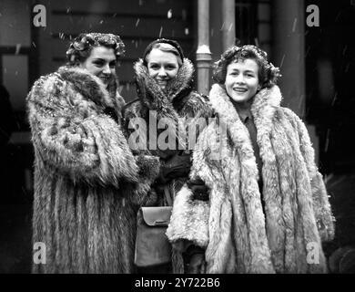 Con i capelli polverati di neve, hanno anticipato il clima artico dell'Inghilterra e sono stati avvolti calorosamente in pellicce e sono arrivati alla Victoria Station , Londra da Parigi per partecipare ad una sfilata Schiaparelli al Ciro's Club . I tre manichini sono a sinistra a destra Nicole , Regine e Ghislaine . 4 dicembre 1950 Foto Stock