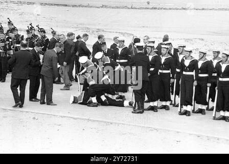 I marinai britannici vanno in aiuto di un compagno svenuto sulle spiagge storiche di Dunkerque il 5 giugno, durante le celebrazioni che celebrano il 25° anniversario dell'evacuazione della British Expeditionary Force dalle spiagge nel giugno 1940, durante la seconda guerra mondiale. Durante i festeggiamenti , 400 dei 337 131 uomini della forza che furono salvati da un' armata di piccole navi britanniche , allineati sulla spiaggia e marciarono verso un servizio di memoria di fronte al semplice memoriale di guerra alleato sulle dune di sabbia . Circa 40 piccole navi che effettivamente presero parte all'evacuazione salparono verso Dunkerque da Ra Foto Stock